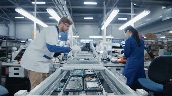 电子工厂工人组装智能手机电路板的时间流逝当他们在装配线上移动高科技工厂设施