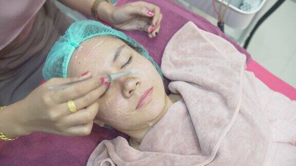 一名护士将透明凝胶涂在一名亚洲妇女的脸上在美容诊所医疗和美容皮肤科预约概念