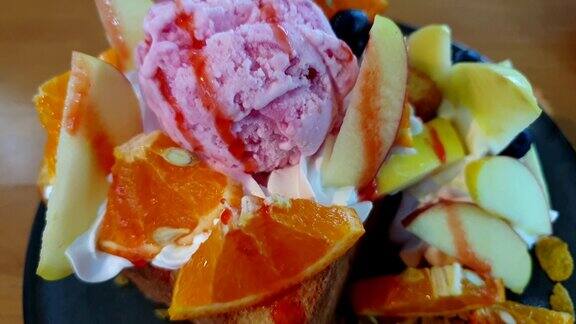 将枫蜜糖浆浇在蜂蜜吐司冰淇淋和水果上