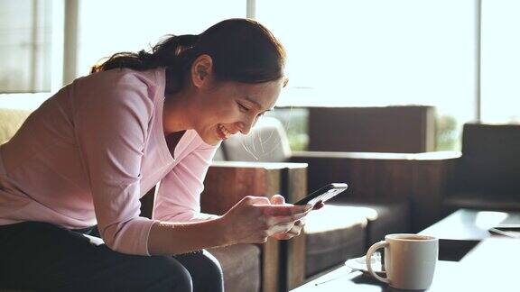亚洲女人在咖啡馆使用智能手机