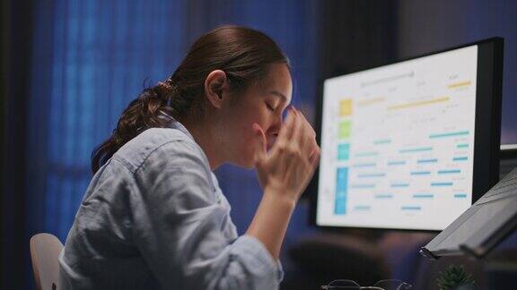 筋疲力尽的女人晚上在家用电脑工作