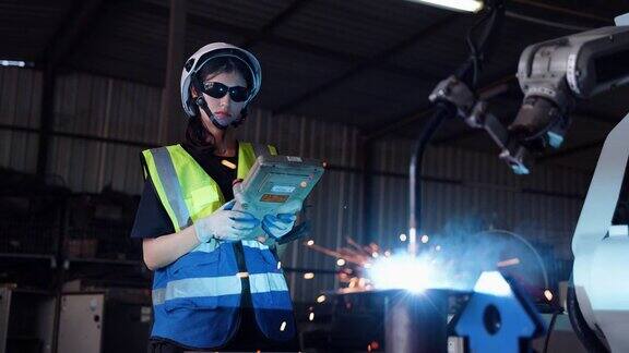 工厂里使用钢铁机器的工人一名男性工程师、技术人员或机械师在仓库中使用焊接机械臂