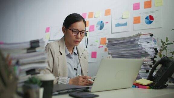 客户支持专家在她的办公室用耳机与客户交谈