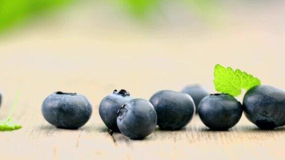 特写新鲜成熟的蓝莓在木桌上慢镜头
