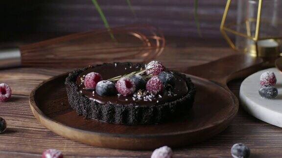 挞巧克力芝士蛋糕与新鲜浆果美味的生日甜点以木桌为背景