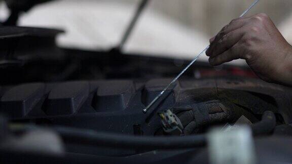 汽车修理工检查车库里发动机油的液位