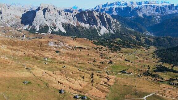 无人机鸟瞰意大利阿尔卑斯山脉的巨大山峰意大利帕索加迪纳缓坡长满草的山顶俯瞰多岩石的白云石山脉