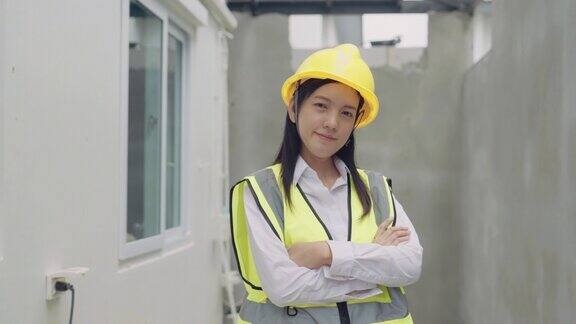 亚洲女工程师在建筑工地双臂交叉站立的肖像
