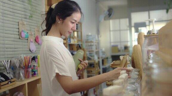 一名亚洲女子在零废物商店为洗面奶加油