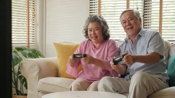 亚洲老年夫妇在家里一起玩游戏心情愉快人们以放松、养老、退休、高级生活方式为家庭观念