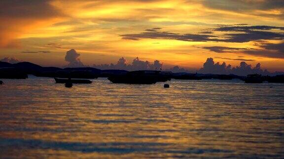 美丽的金云日落与渔船在泰国芭堤雅的海洋上
