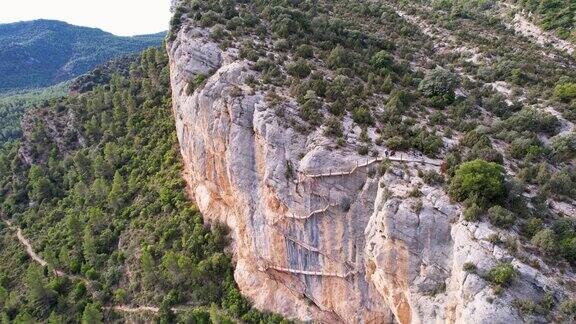 全景美丽的令人眩晕的鸟瞰图岩石悬崖上的木制楼梯是CongostdeMontrebei峡谷徒步旅行路径的一部分在加泰罗尼亚比利牛斯山脉被河流上的植被包围