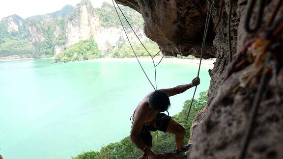 4K亚洲人在夏天爬上热带岛屿的岩石山
