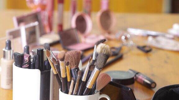 化妆师使用的化妆品和化妆工具摆放在木桌上