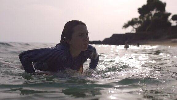 冲浪的女人在大海里等待着海浪