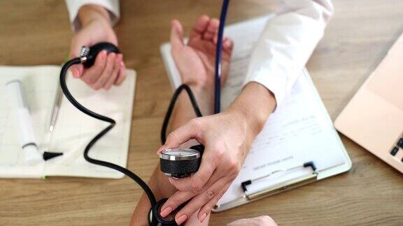 医生治疗师在诊所用血压计测量病人的血压近距离4k电影慢动作
