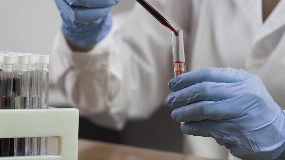 科学家将血液滴入试管的特写镜头