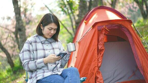 女人在山上露营在休息时间喝咖啡