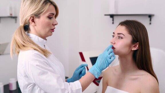 整形外科医生或美容专家检查女人的脸用手触摸检查愈合后的皮肤手术与惊人的结果病人在主诊医生处做检查