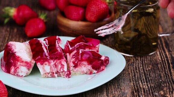 用叉子拿一个草莓蛋糕加芝士奶油和果酱