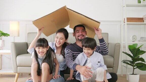 亚洲家庭在客厅玩耍用想象力建造纸板房子