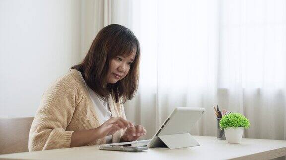 女性自由职业者在家里使用数字平板电脑工作