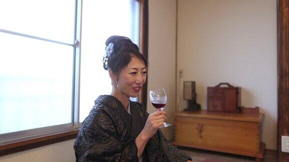 穿着和服的日本女人在日本榻榻米的房间谈论和喝葡萄酒
