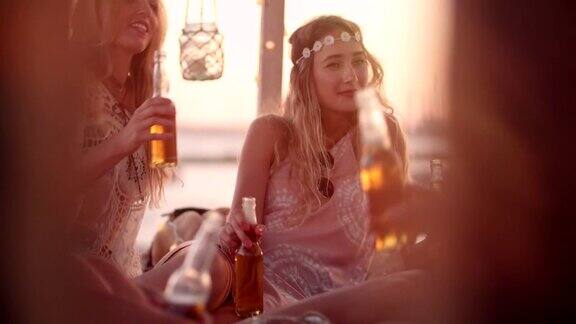 年轻的朋友在夏日岛的海滩酒吧喝啤酒