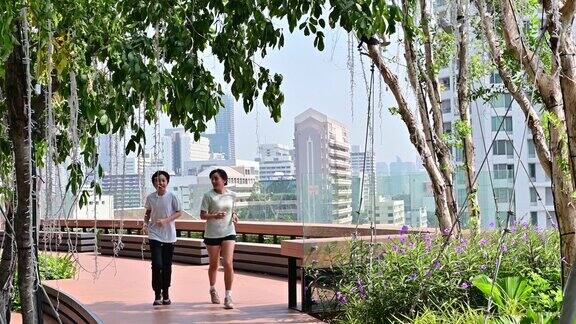 4K亚洲母亲和儿子在现代城市背景下跑步