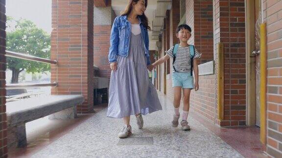 年轻的亚洲母亲带着她的小女儿去上学