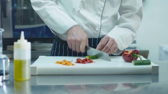 商业厨房里的专业厨师正在切绿色蔬菜