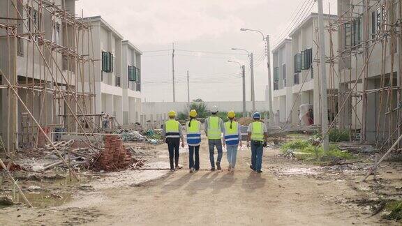 多样化的专家团队一名拉丁投资者一名工程师一名亚洲女工一名高级电气男走过现场房屋建设开发项目后视图