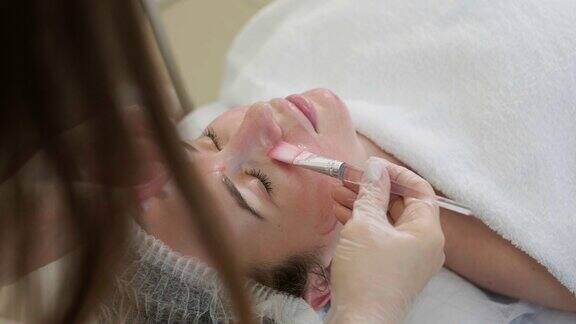 美容师做面部护理和敷面膜