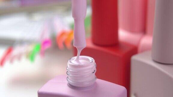 打开一瓶粉红色的啫喱指甲油刷子上有流动的厚漆