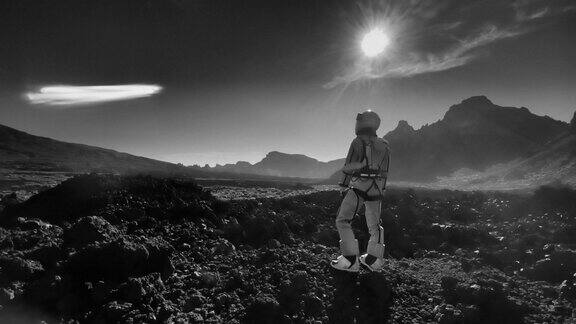 月球漫步女宇航员探索灰色山脉看着干燥的火山地貌