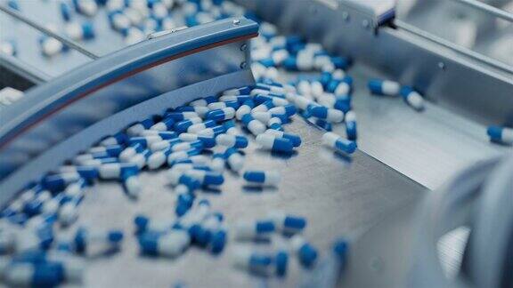 现代制药厂蓝色胶囊在传送带上移动片剂和胶囊制造工艺药品生产线特写镜头