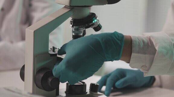 实验室技术人员在显微镜下准备载玻片进行分析