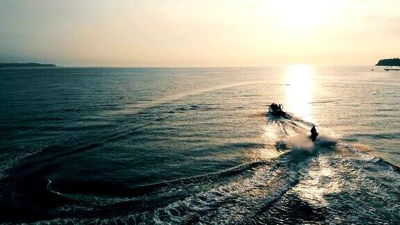 海上日落两艘摩托艇在海湾中滑行