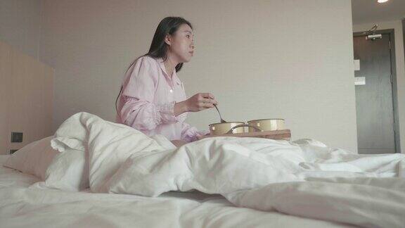 东南亚妇女在床上吃早餐