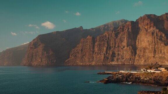 西班牙加那利群岛特内里费岛日落时洛斯吉甘特悬崖附近平静的海景火山黑色岩石海滩日落时的海水景观