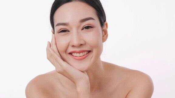 微笑的亚洲妇女肖像应用面霜与白色的背景