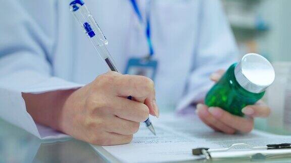 特写女药剂师在纸上手写药品细节