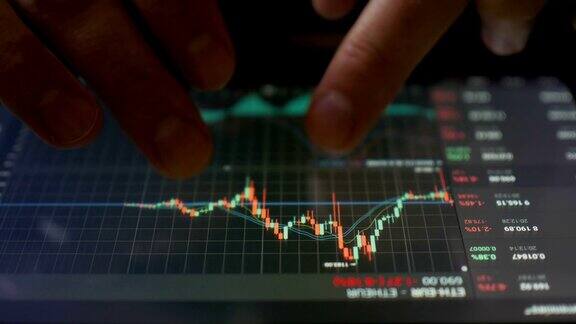 股票市场在线交易交易员在股市交易大厅用平板电脑工作触摸式触摸屏浏览外汇市场数据、图表外汇加密的货币比特币cryptocurrency