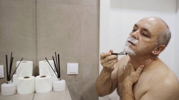 一个四十岁的男人用剃刀刮脸