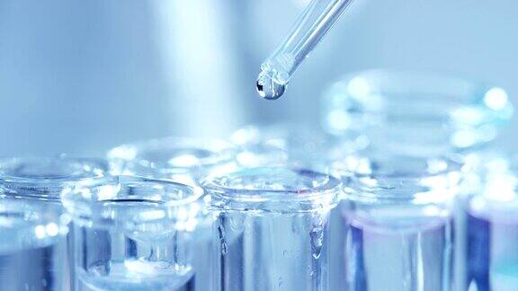 在实验室里科学家用吸液管分析有色液体提取试管中的DNA和分子