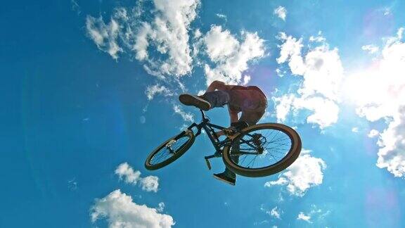 SLOMO男性自行车做了一个没有手没有脚的把戏而在他的DJ自行车空中