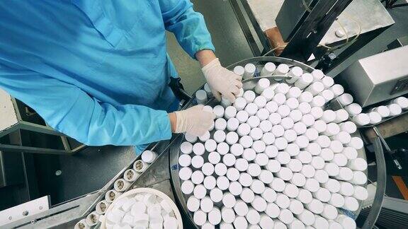 制药厂生产线药理学家正把药桶移到传送带上
