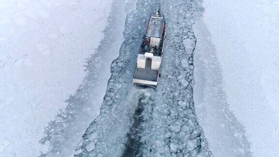 无人机追逐在结冰湖面上移动的一艘小型破冰船
