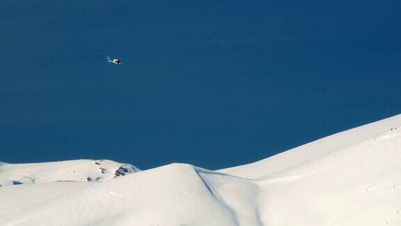 直升机在雪山的背景下飞行