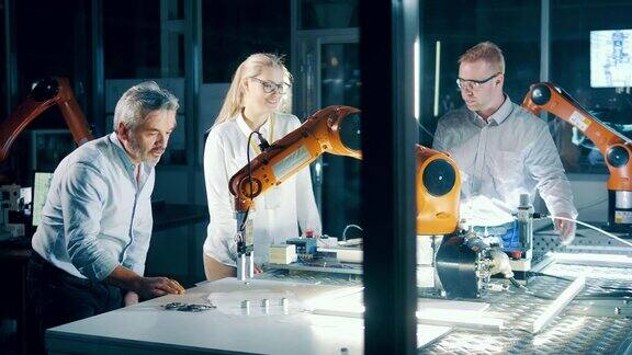 工程师们在一个现代化的实验室里与工业机器人一起工作